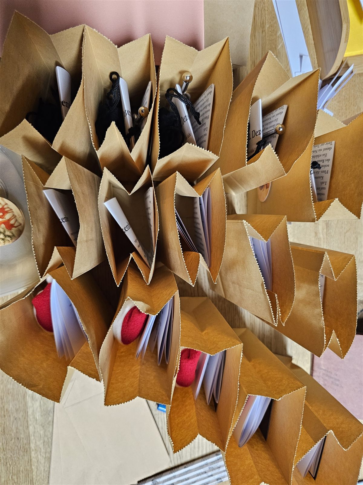 Offene Papiertüten mit gefalteten Rätselblättern und kleinen Geschenken beim Befüllen des Adventskalenders.