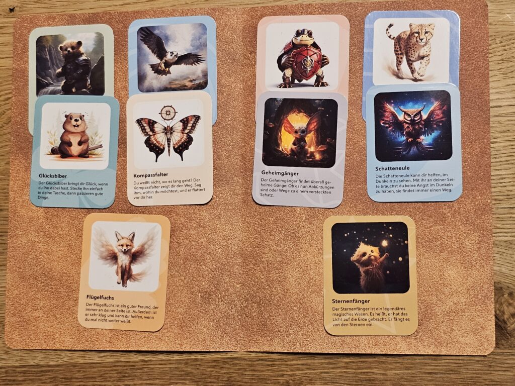 Bunte Sammelkarten mit magischen Tierwesen aus einer Rätselgeschichte auf einer Korkunterlage.